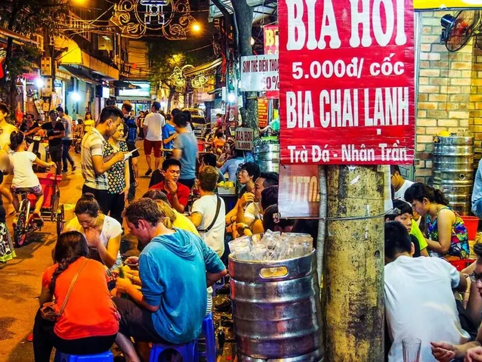 Busy Bia Hơi corner with pavement tables and fresh draught beer in Hanoi