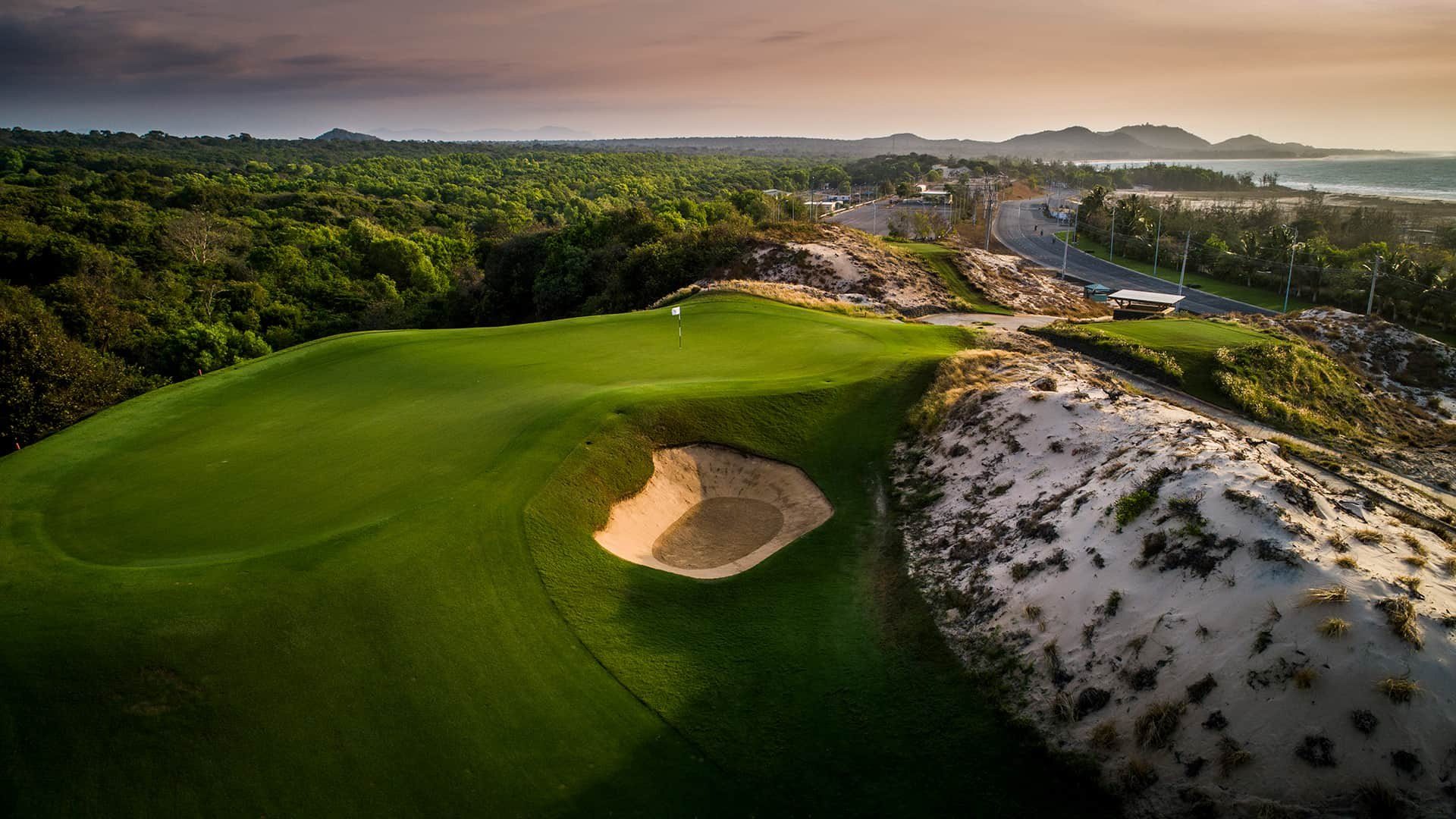 Dramatic dunes and bunkers at The Bluffs Grand Ho Tram in golden light, Southern Vietnam