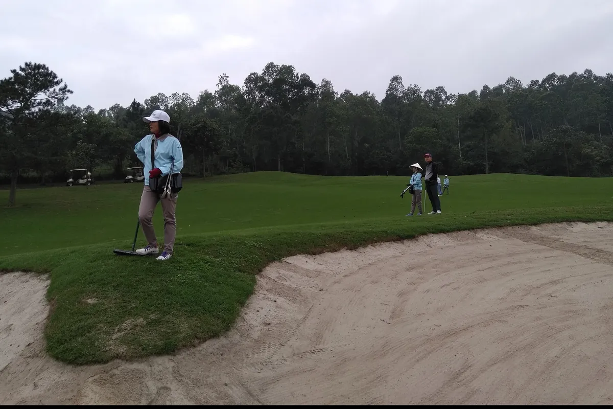Golfers beside a greenside bunker at Tam Dao Golf Resort